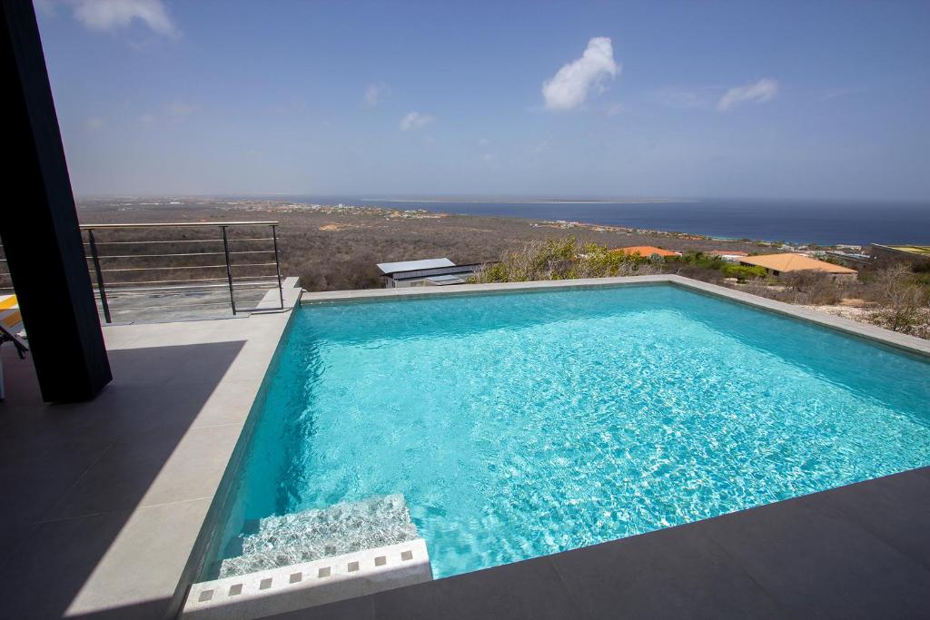 a swimming pool with a view of the ocean at Villa Casawa in Kralendijk
