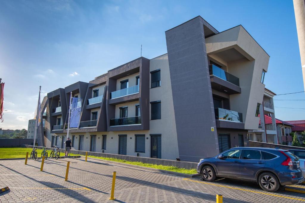 een auto geparkeerd voor een gebouw bij Enjoy Life Apartments in Techirghiol