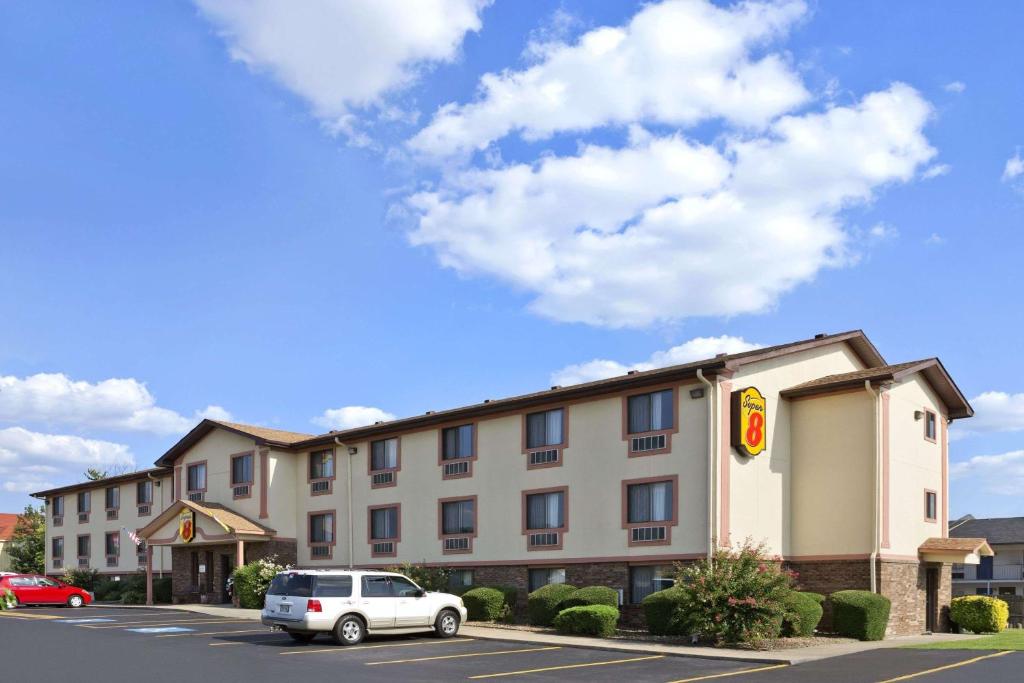 a hotel with a car parked in a parking lot at Super 8 by Wyndham Russellville in Russellville