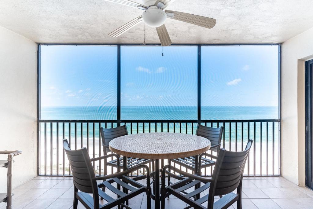 a table and chairs on a balcony with a view of the ocean at Reflections Gulf Front Condo With Ocean Views in Clearwater Beach