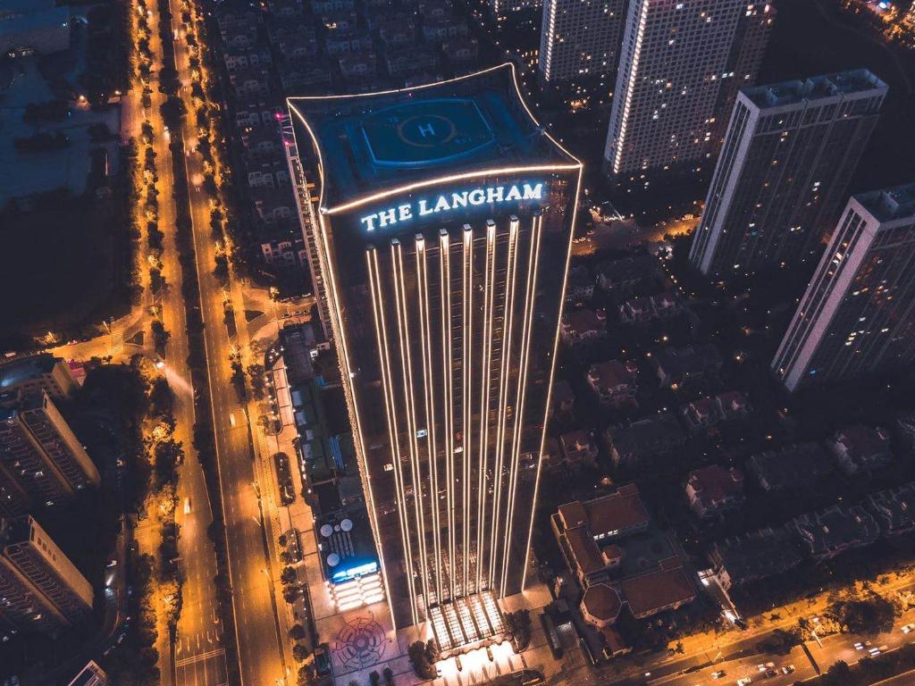 a tall building with the laminar sign on it at night at The Langham, Hefei in Hefei