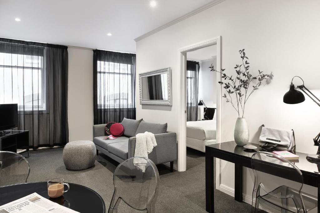 a living room filled with furniture and a large window at Punthill Apartment Hotel - Flinders Lane in Melbourne