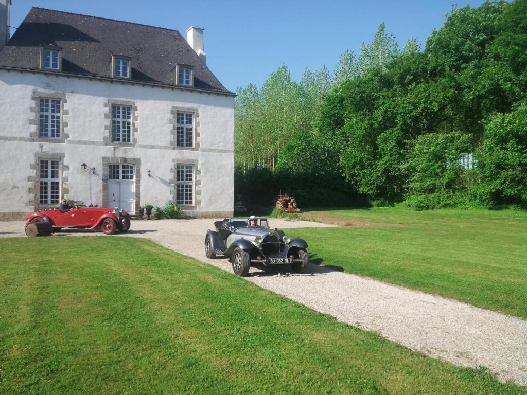 zwei alte Autos, die vor einem Haus geparkt sind in der Unterkunft Les Trauchandieres de Saint Malo in Saint-Jouan-des-Guérets