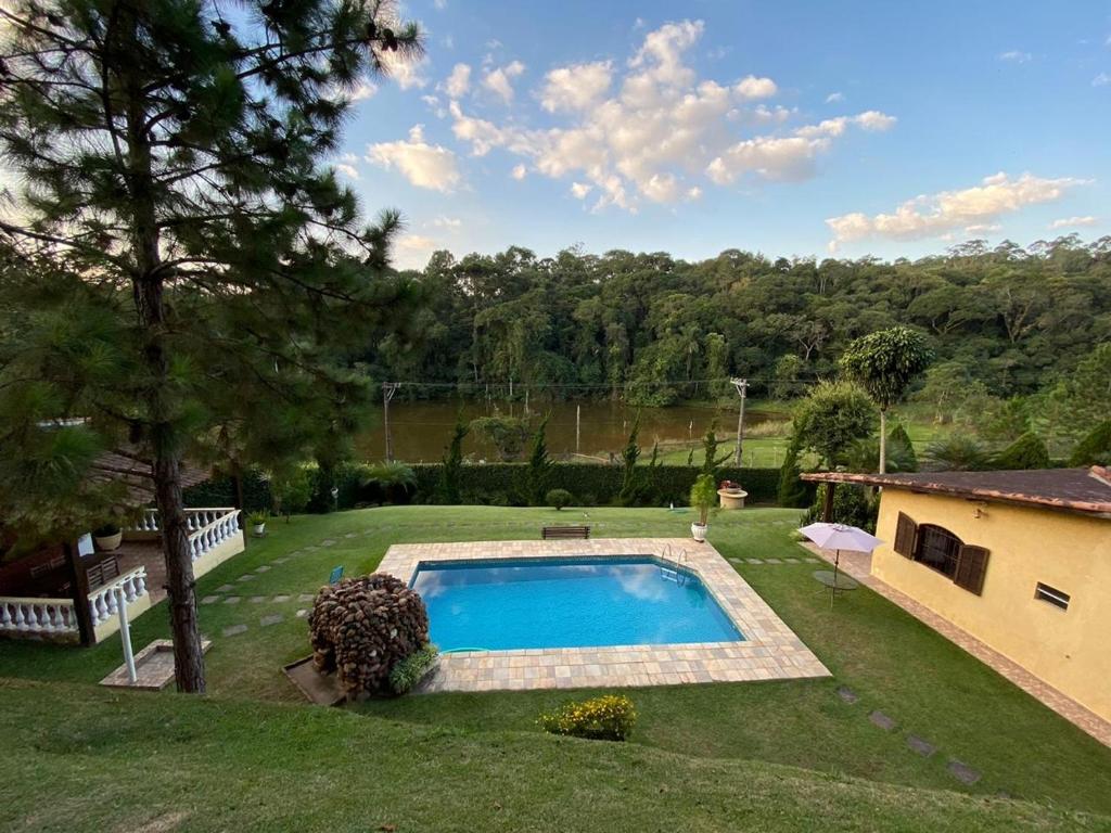 a yard with a swimming pool and a house at Chácara do Darcio SP in Itapecerica da Serra