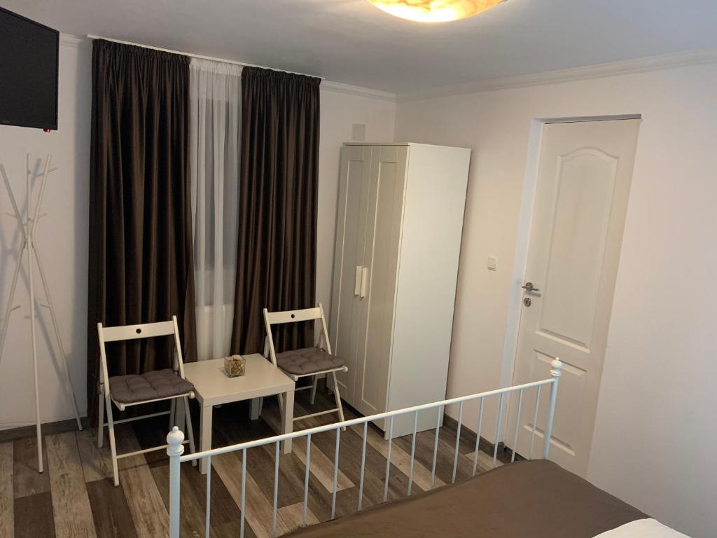 - une chambre avec 2 chaises, une table et un miroir dans l'établissement Casa De Sub Munte, à Buşteni
