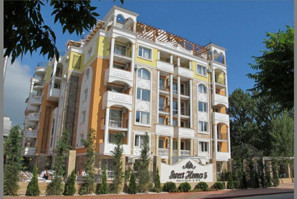 サニービーチにあるApart Sweet Homes 5 - Apartments for guestsの黄白の外観のアパートメントビル