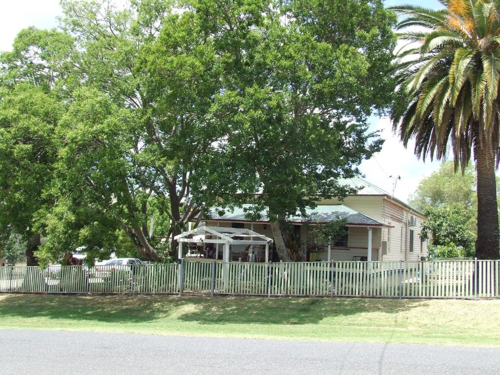 a fence in front of a house with a palm tree at Killarney Country Living in Killarney