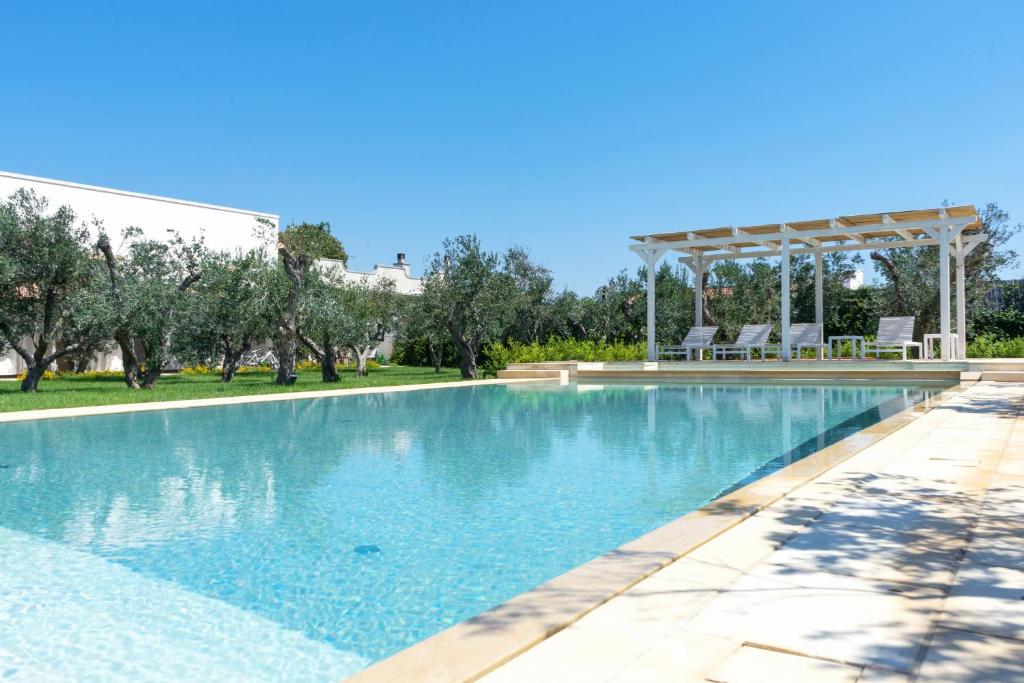 una piscina con gazebo e alberi di Relais L'Oliveto a Surano