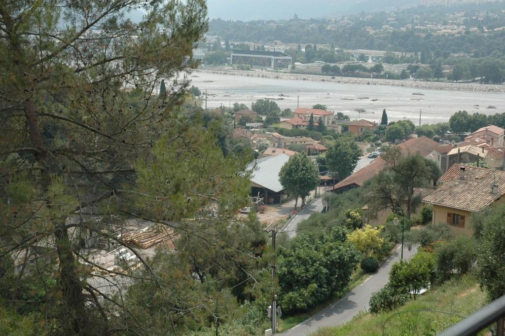 uitzicht op een stad met een rivier en bomen bij La vigne sous les pins in Castagniers