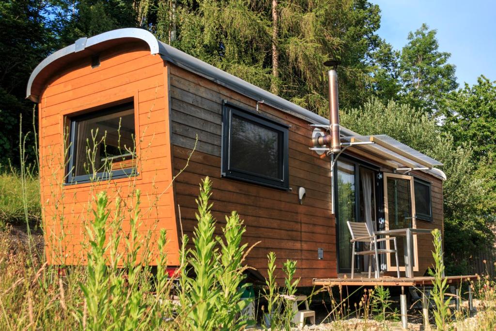 an orange tiny house sitting in a field at Tiny House Steirerbua in Birkfeld