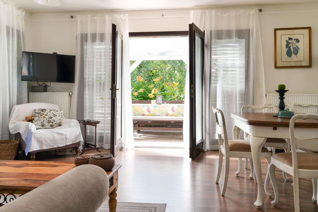 uma sala de estar com uma mesa e cadeiras e uma televisão em Wéber Villa em Gyenesdiás