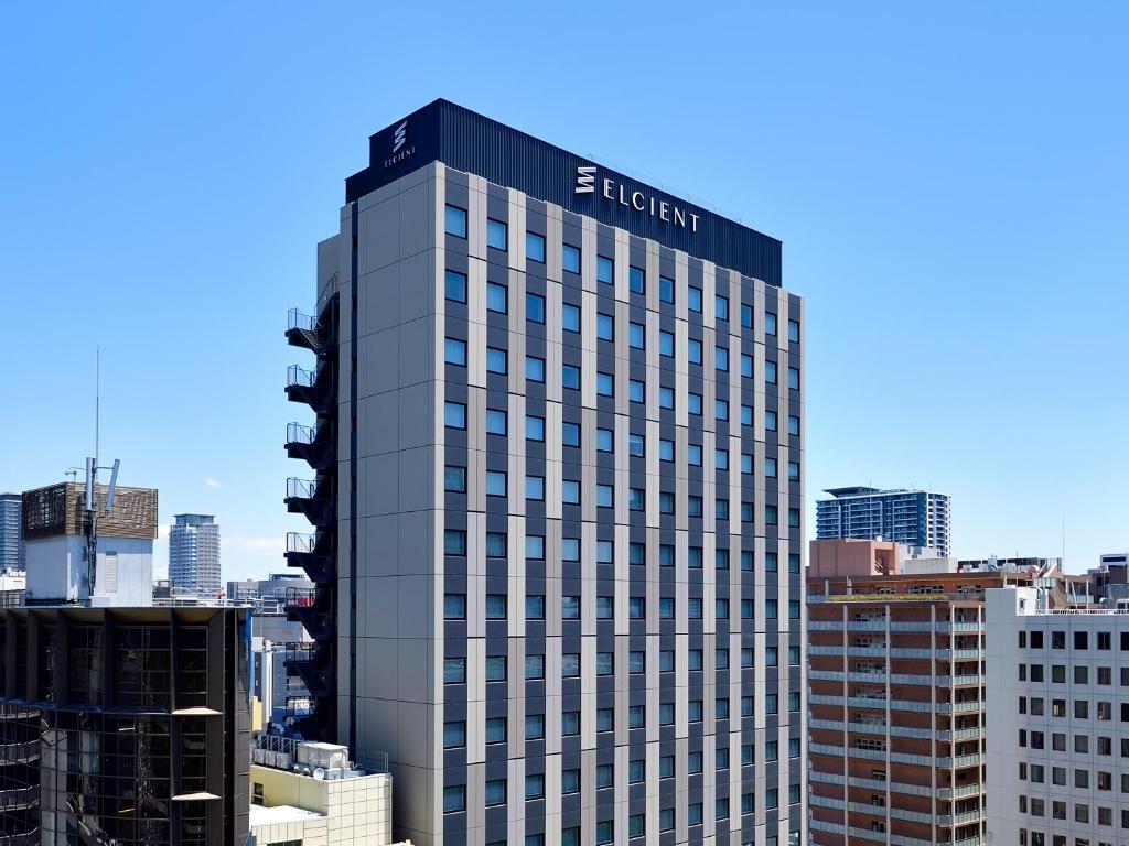 a tall building with the egypt sign on top of it at Hotel Elcient Osaka Umeda in Osaka