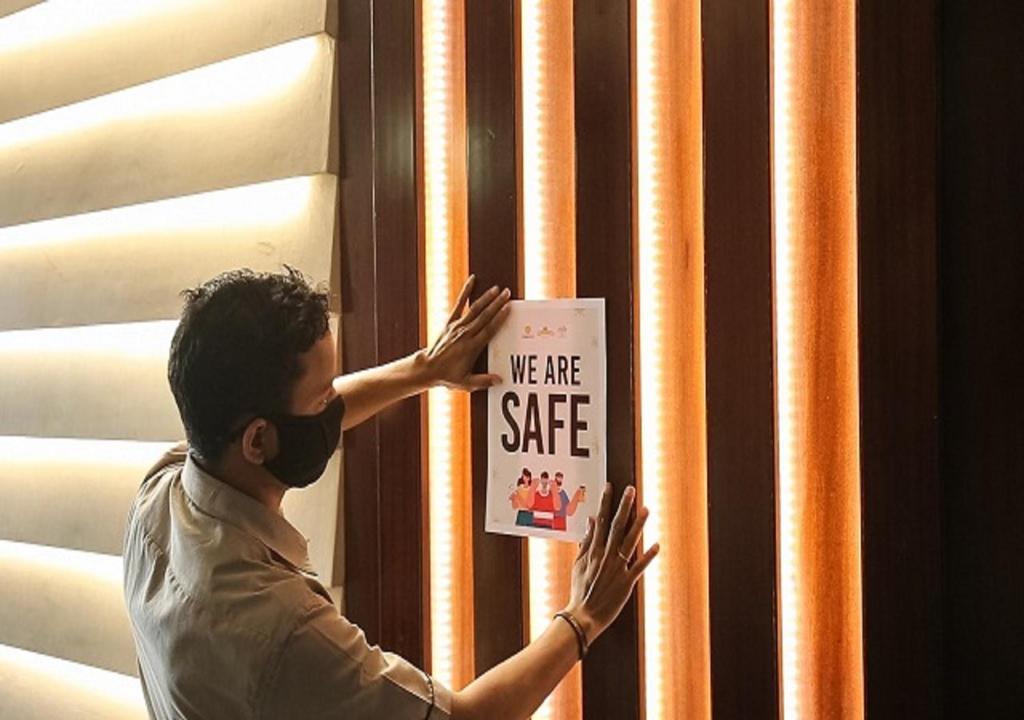 un hombre sosteniendo un cartel que dice que estamos a salvo en Mango Suites Viera, en Hyderabad