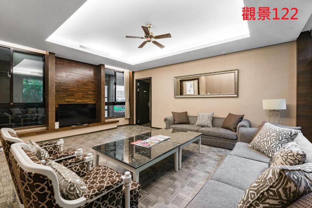 a living room with a couch and a table at Great Roots Forestry Spa Resort in Sanxia
