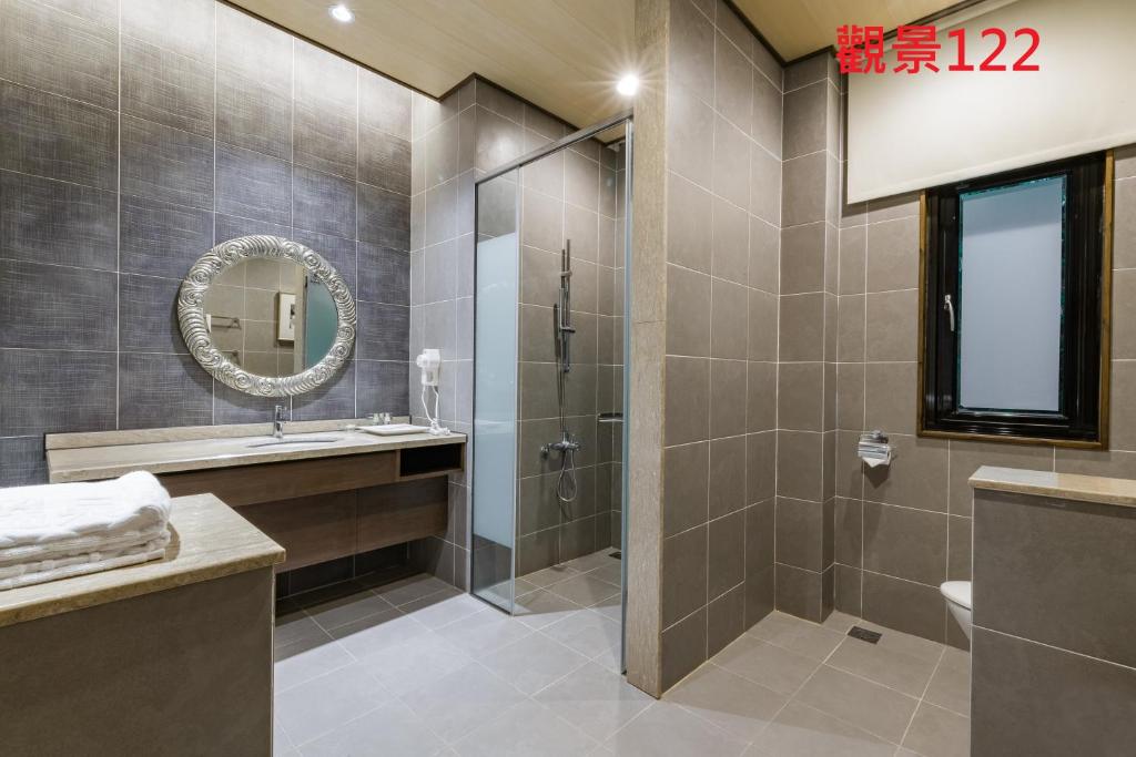 a bathroom with a shower and a sink and a mirror at Great Roots Forestry Spa Resort in Sanxia