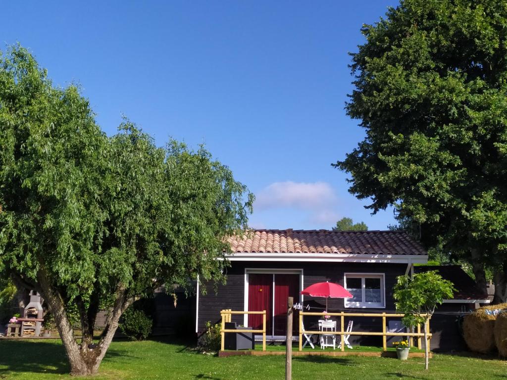 una casa con tavolo e porta rossa di le gite de léonard a Castelnau-dʼEstrétefonds