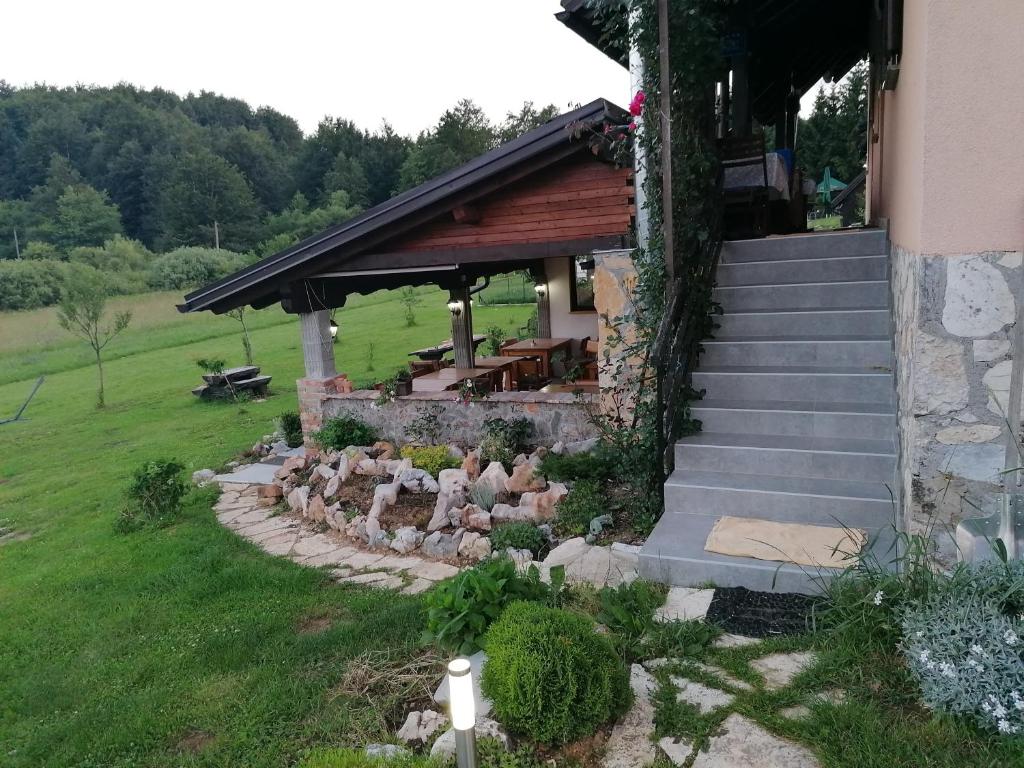 un edificio con porche y escaleras junto a un patio en House Izvor, en Jezerce