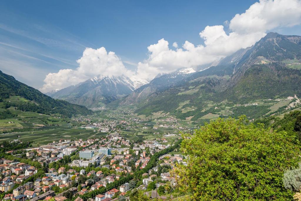 an aerial view of a town in a valley with mountains at Hotel Bellevue in Tirolo