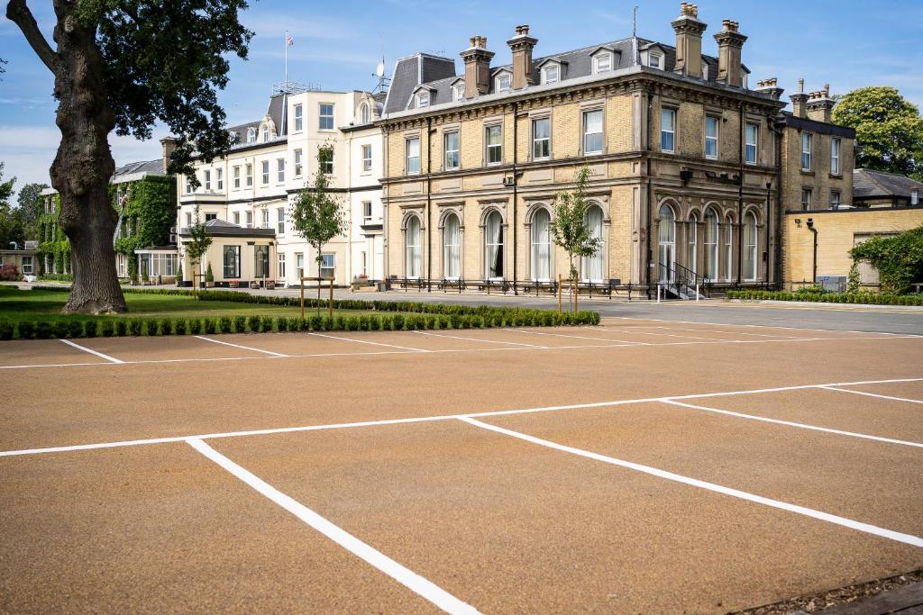 um campo de ténis vazio em frente a um edifício em The Spa Hotel em Royal Tunbridge Wells