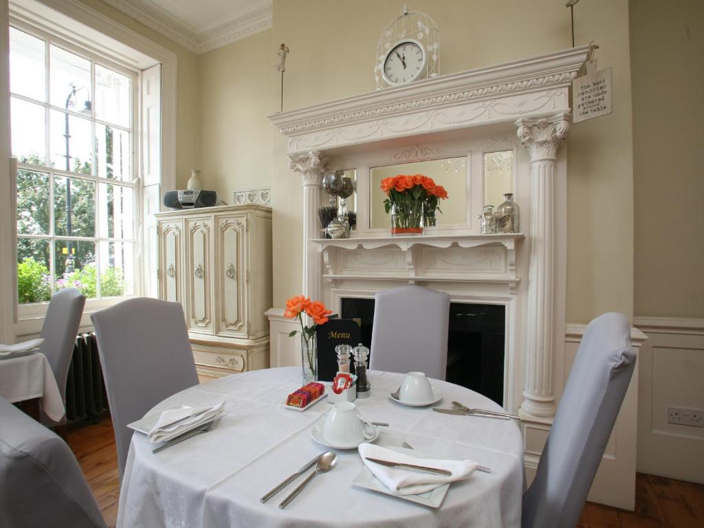 a dining room with a table and a fireplace at Hamiltons Boutique Hotel in Southend-on-Sea