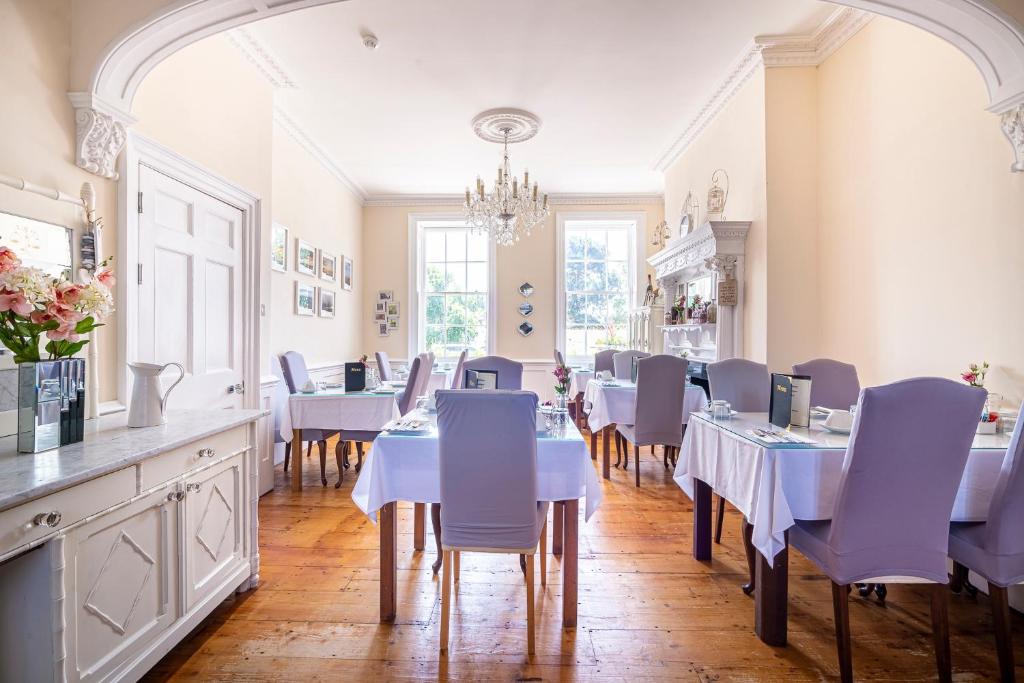 a dining room with white tables and purple chairs at Hamiltons Boutique Hotel in Southend-on-Sea