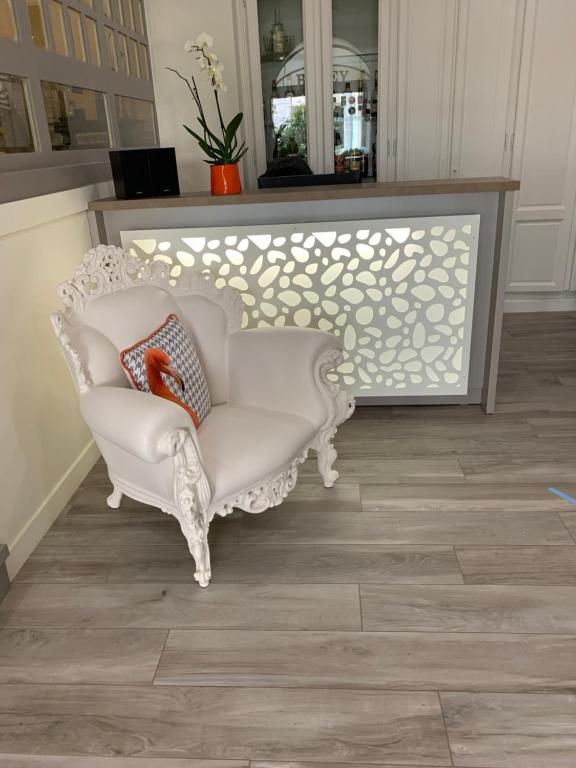 a white chair in a room with a mirror at Hotel Biney in Rodez