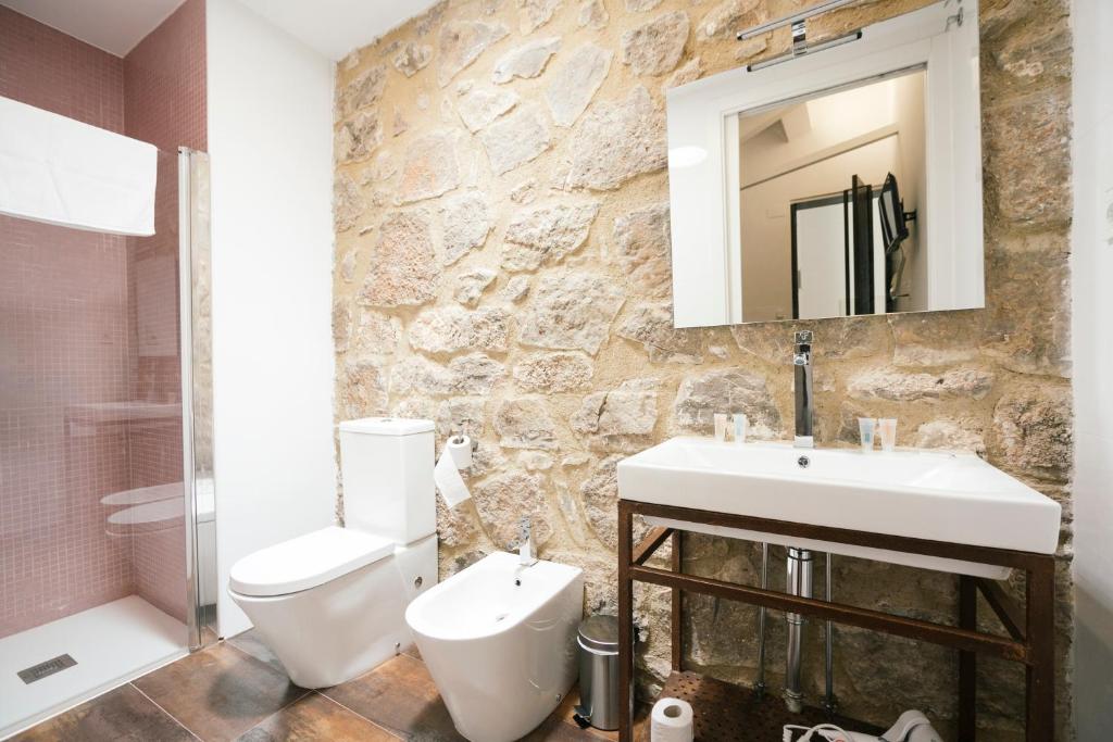 a bathroom with a sink and a toilet and a mirror at La Albacara in Moya