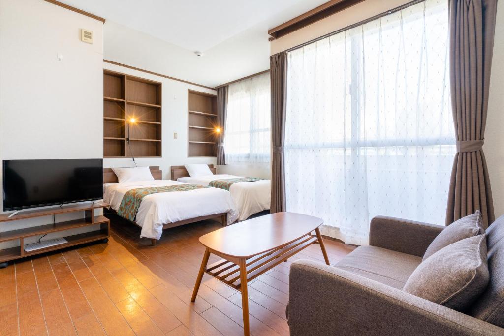 a hotel room with two beds and a television at Kent Clair Ishigaki Bay in Ishigaki Island