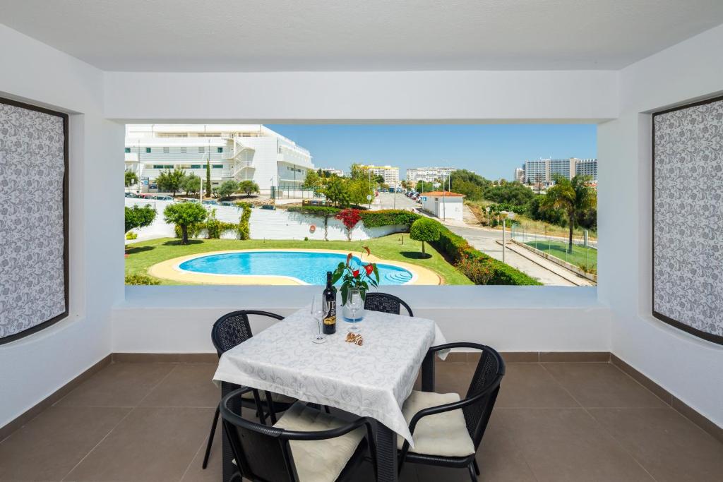 une salle à manger avec une table et des chaises et une vue sur la piscine dans l'établissement AlbufeiraMar Apartment, à Albufeira
