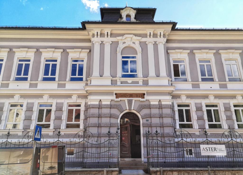 a large white building with a clock tower on top at NaturparkResort Alte Schule in Hieflau