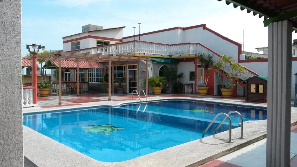 a large swimming pool in front of a building at Hotel y Bungalows Monteverde in Chachalacas