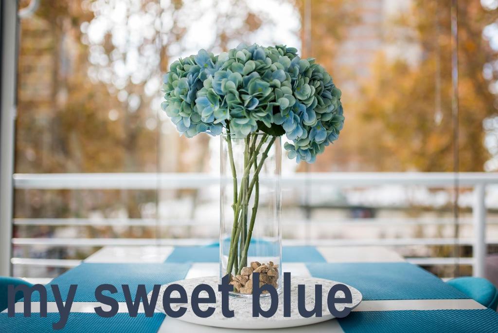 une fleur bleue dans un vase sur une table dans l'établissement My Sweet Blue Apartment, à Benidorm