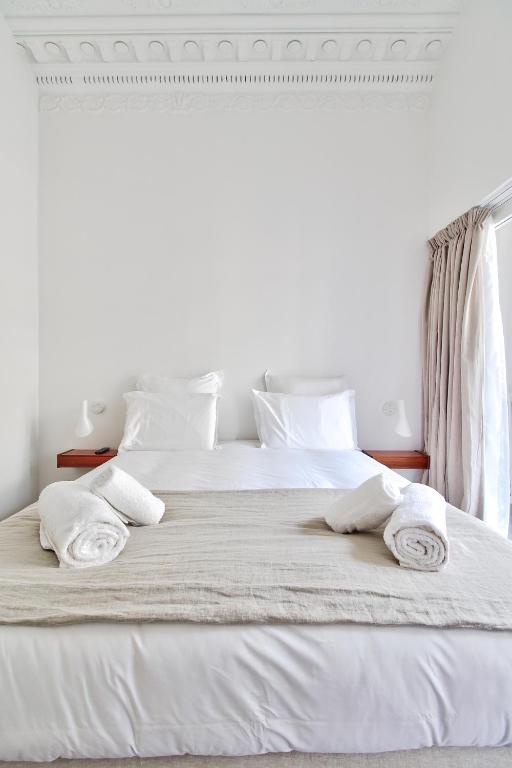 a white bed with two towels on top of it at Modern Apt 3BDR&#47;3BATH - Louvre Museum&#47;Tuileries in Paris