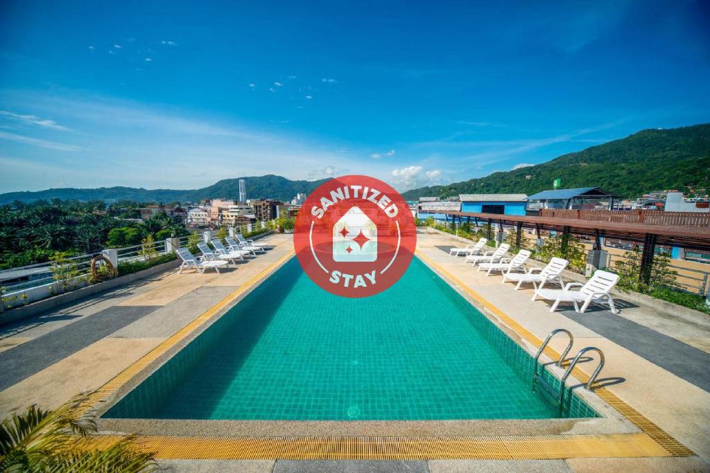 a swimming pool on the roof of a building with chairs at I Dee Hotel Patong in Patong Beach