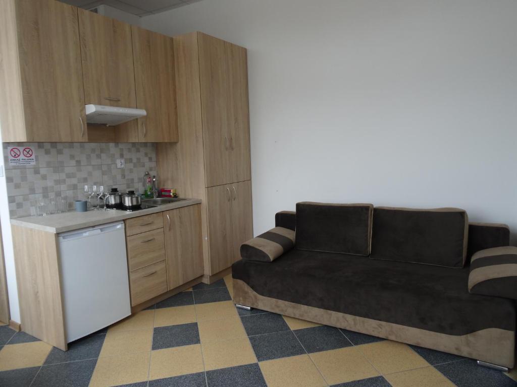 a living room with a couch and a kitchen at Nowy Apartament Słoneczny in Augustów