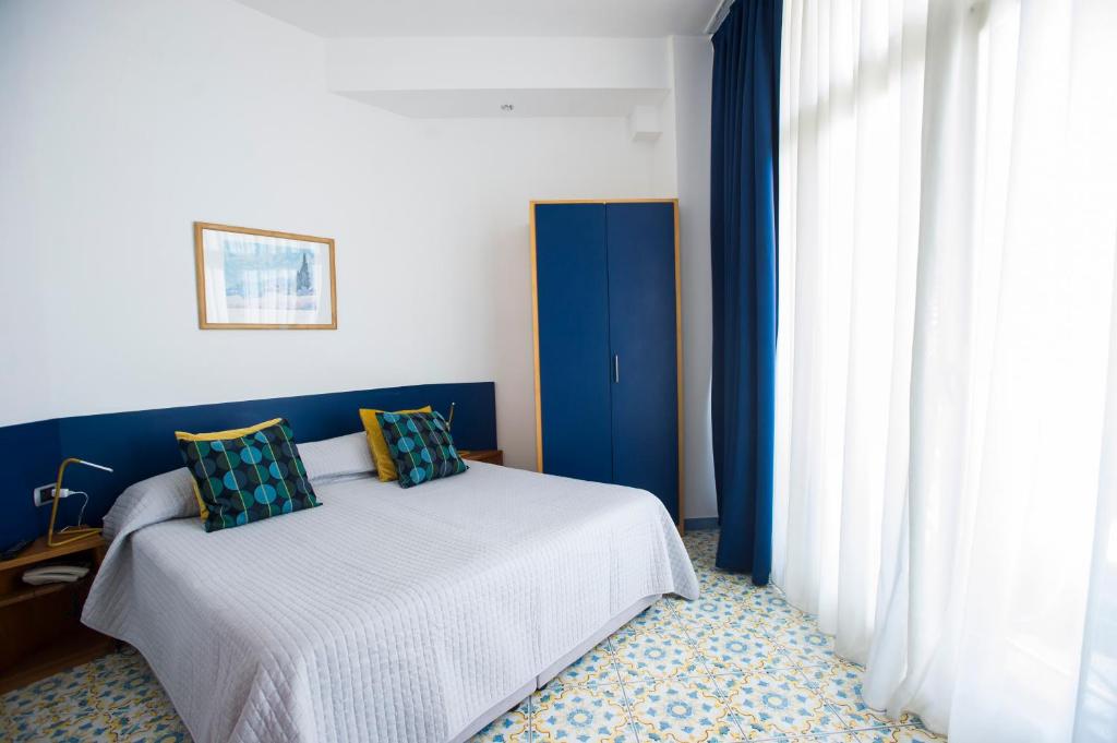 a bedroom with a bed with blue walls and a window at Residence Panoramic in Maiori