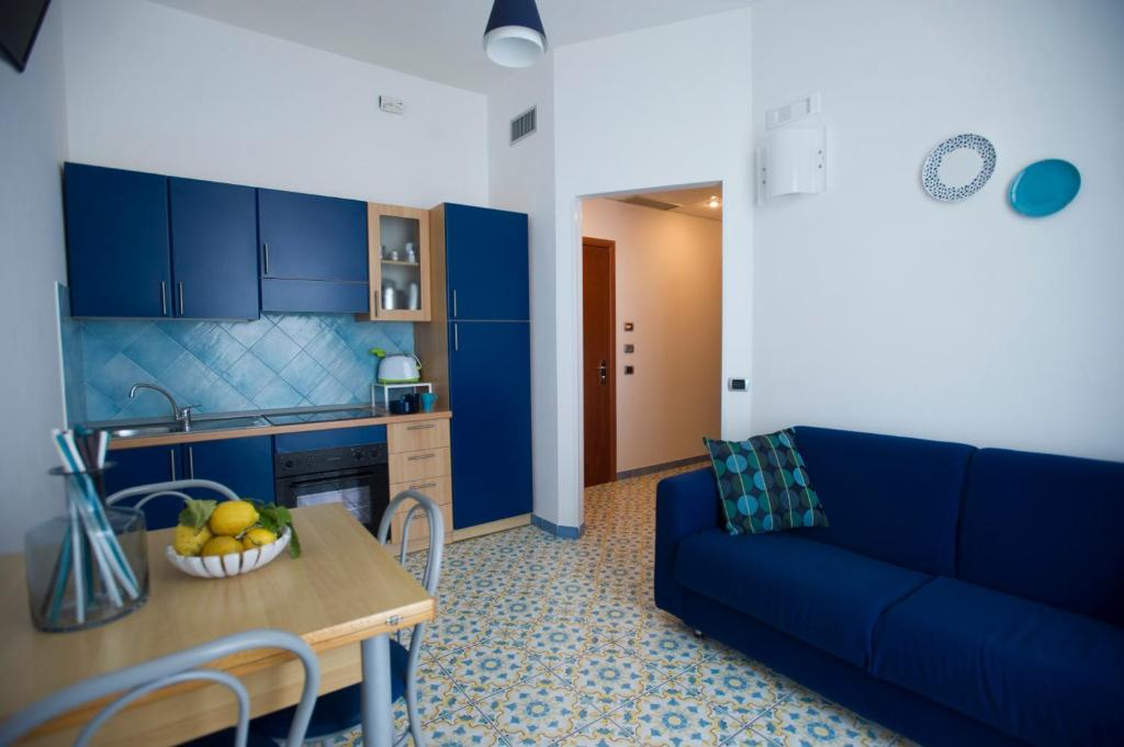 a living room with a blue couch and a table at Residence Panoramic in Maiori