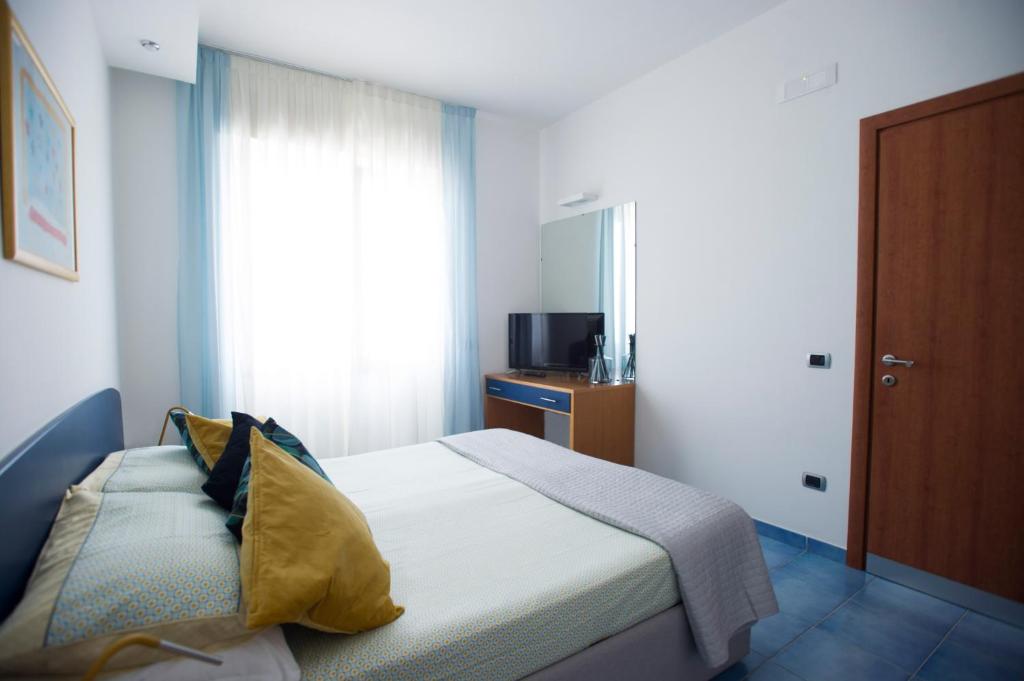 a bedroom with a bed and a window and a television at Residence Panoramic in Maiori