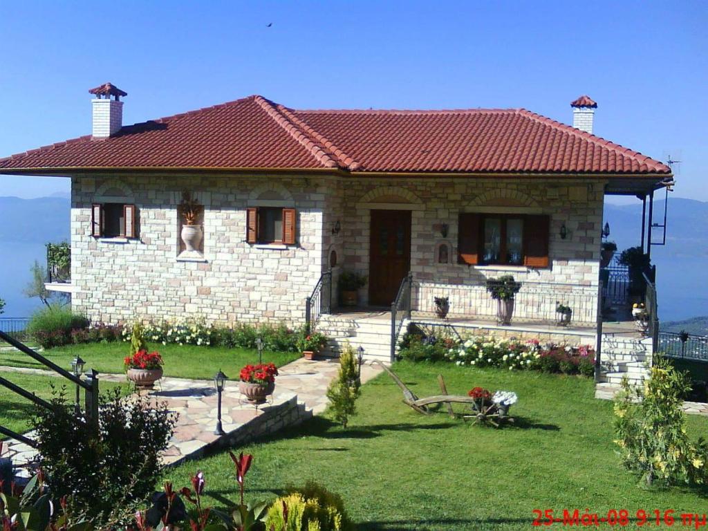 una pequeña casa de ladrillo con techo rojo en Balcony on Trichonida Lake en Kríon Nerón