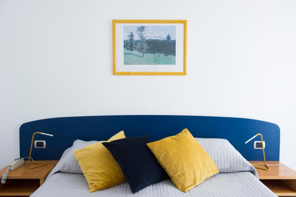 a bed with a blue head board with two lamps at Residence Panoramic in Maiori