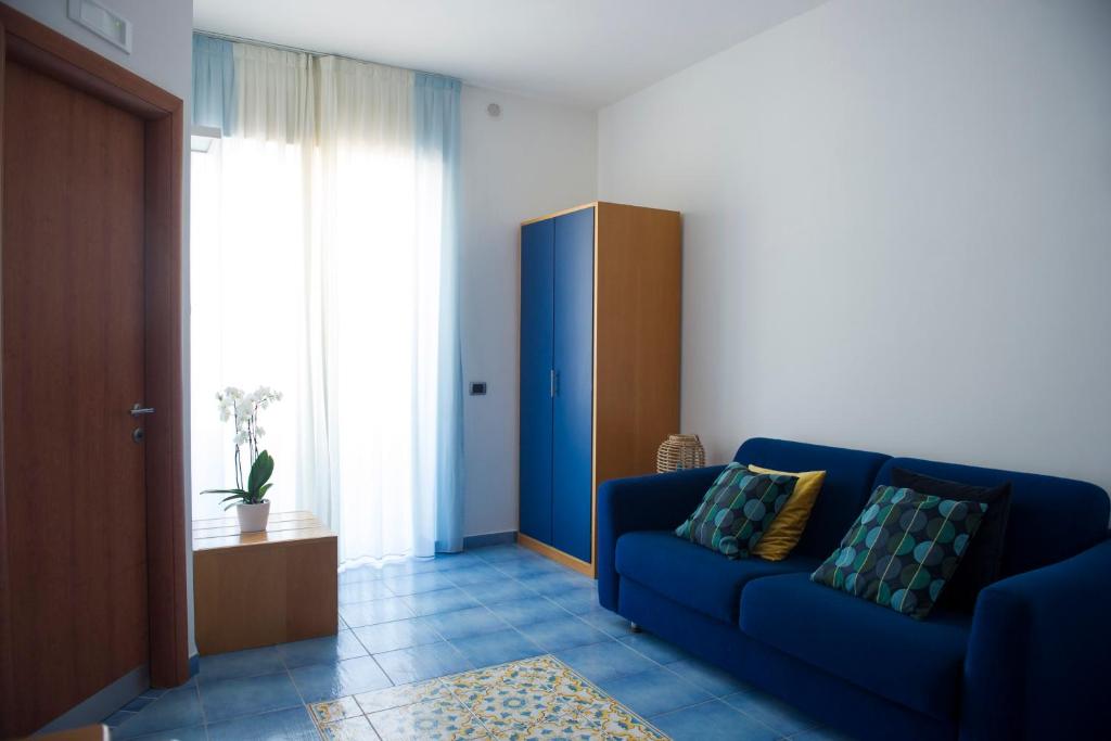 a living room with a blue couch and a window at Residence Panoramic in Maiori
