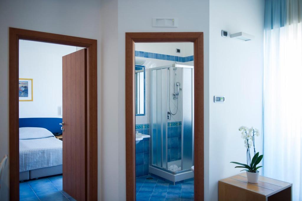 a bathroom with a shower and a bed and a mirror at Residence Panoramic in Maiori