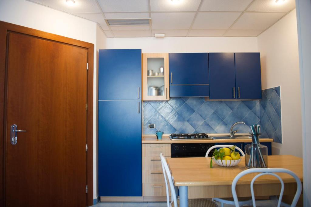 a kitchen with blue cabinets and a wooden table at Residence Panoramic in Maiori
