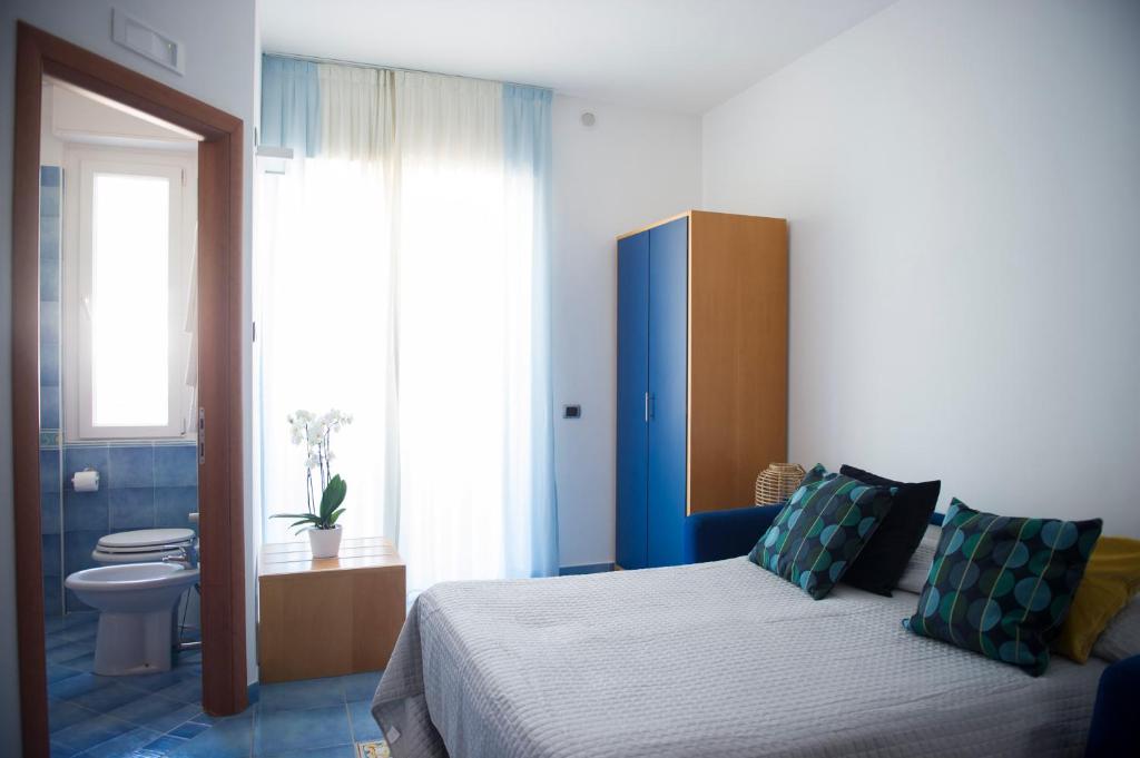 a bedroom with a bed and a bathroom with a toilet at Residence Panoramic in Maiori