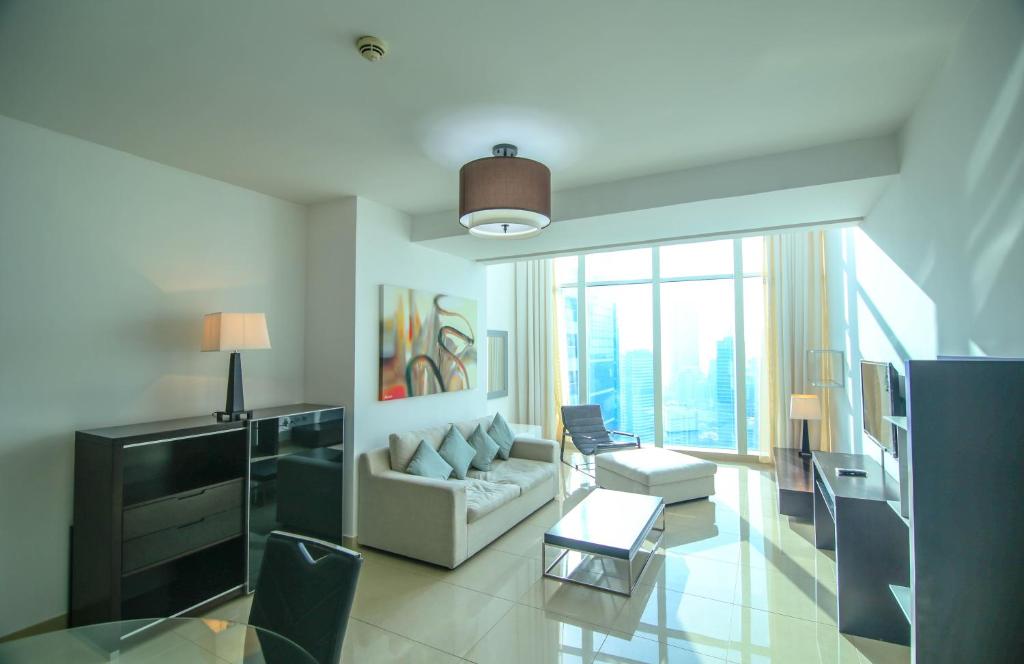 a living room with a couch and a large window at Lux BnB Laguna Tower Penthouse JLT in Dubai