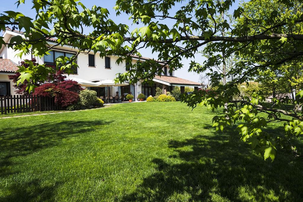 un patio con césped verde y una casa en Agriturismo il Cascinale en Treviso