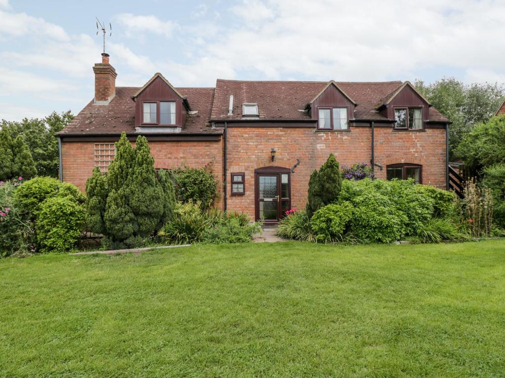 a large brick house with a large yard at Lawn Farm Cottage in Gloucester
