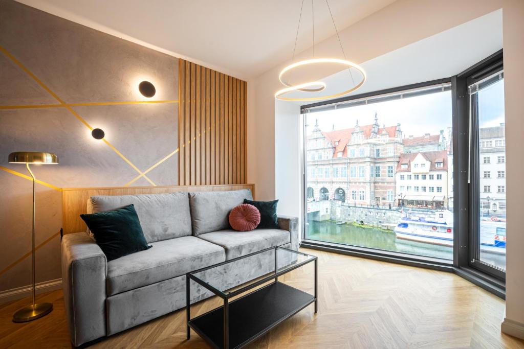 a living room with a couch and a large window at Apartament DEO PLAZA in Gdańsk