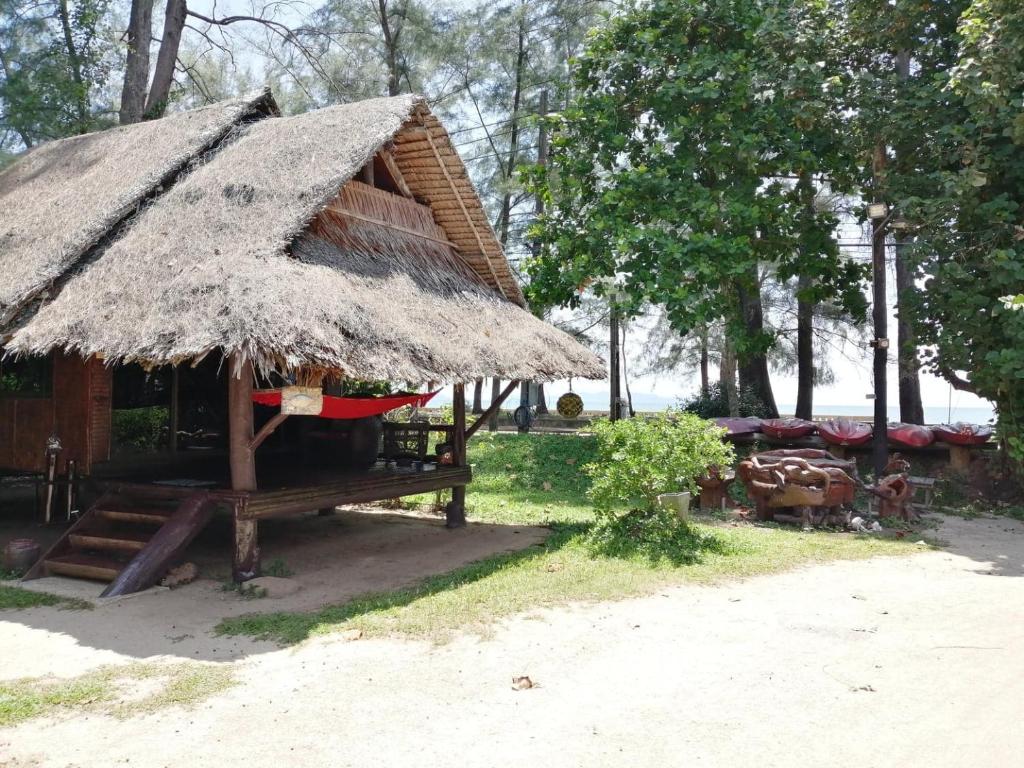 eine Hütte mit einem Strohdach am Strand in der Unterkunft Fisherman's Hut , ขนำชาวเลโฮมสเตย์ in Pak Meng