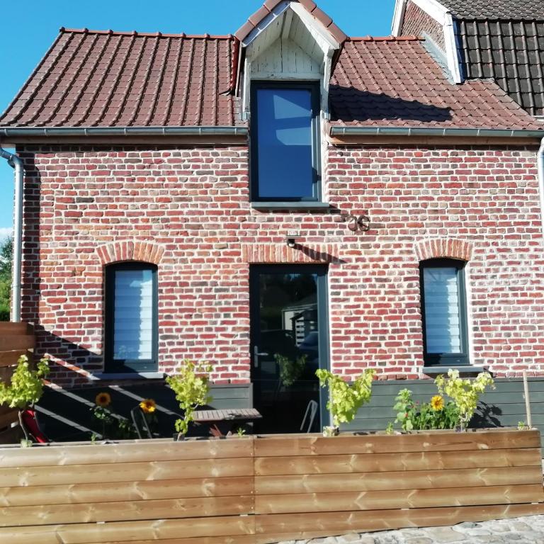 une maison en briques avec un toit rouge dans l'établissement La Petite Pause, à Verlinghem